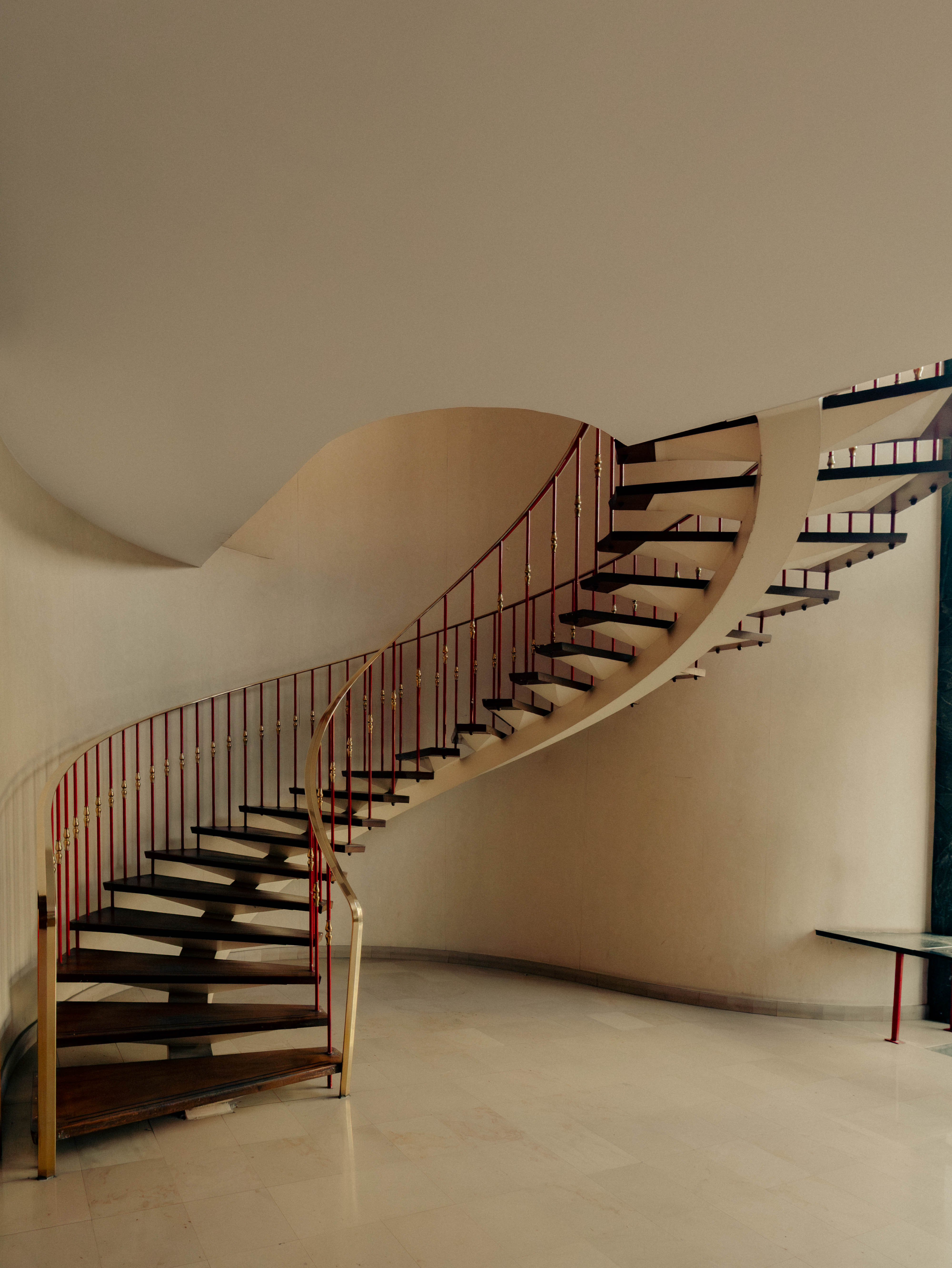 Escalier hélicoïdal suspendu, garde-corps rouge et laiton