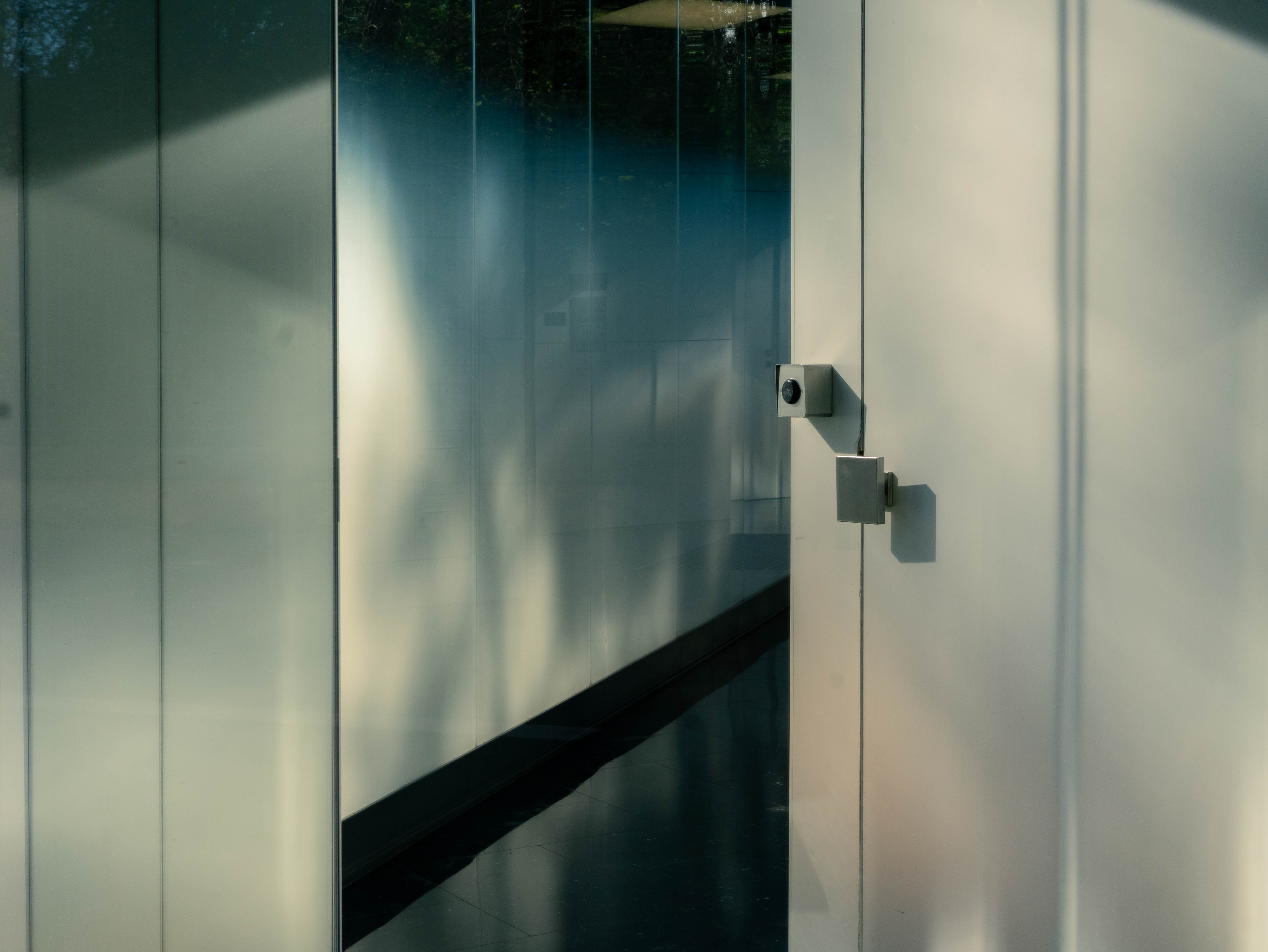 Porte verre dépoli, ferrure inox carrée, reflets d'arbres