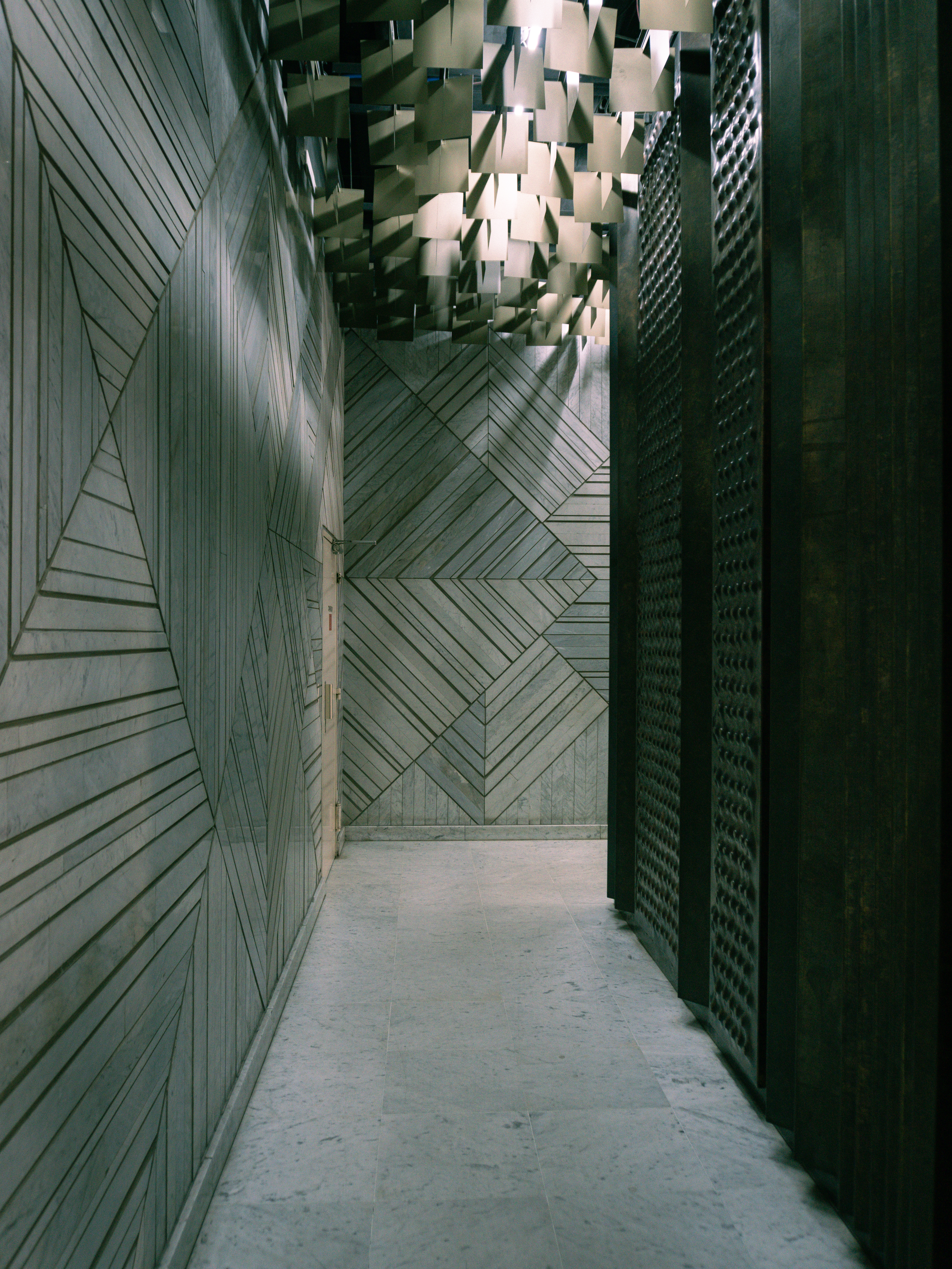 Couloir marbre aux motifs gravés, plafond feuilles métal doré