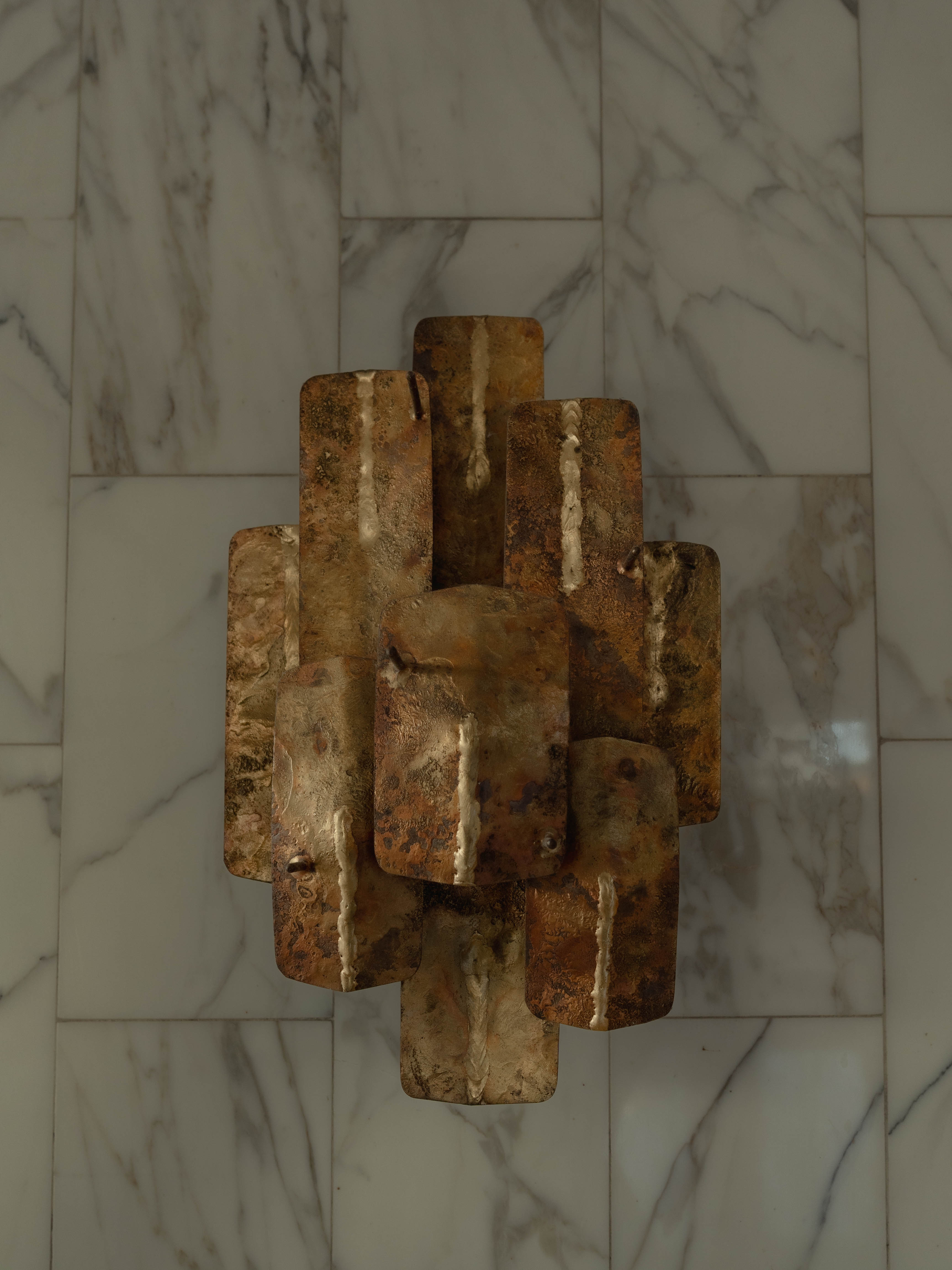 Applique murale brutale métal oxydé sur marbre blanc