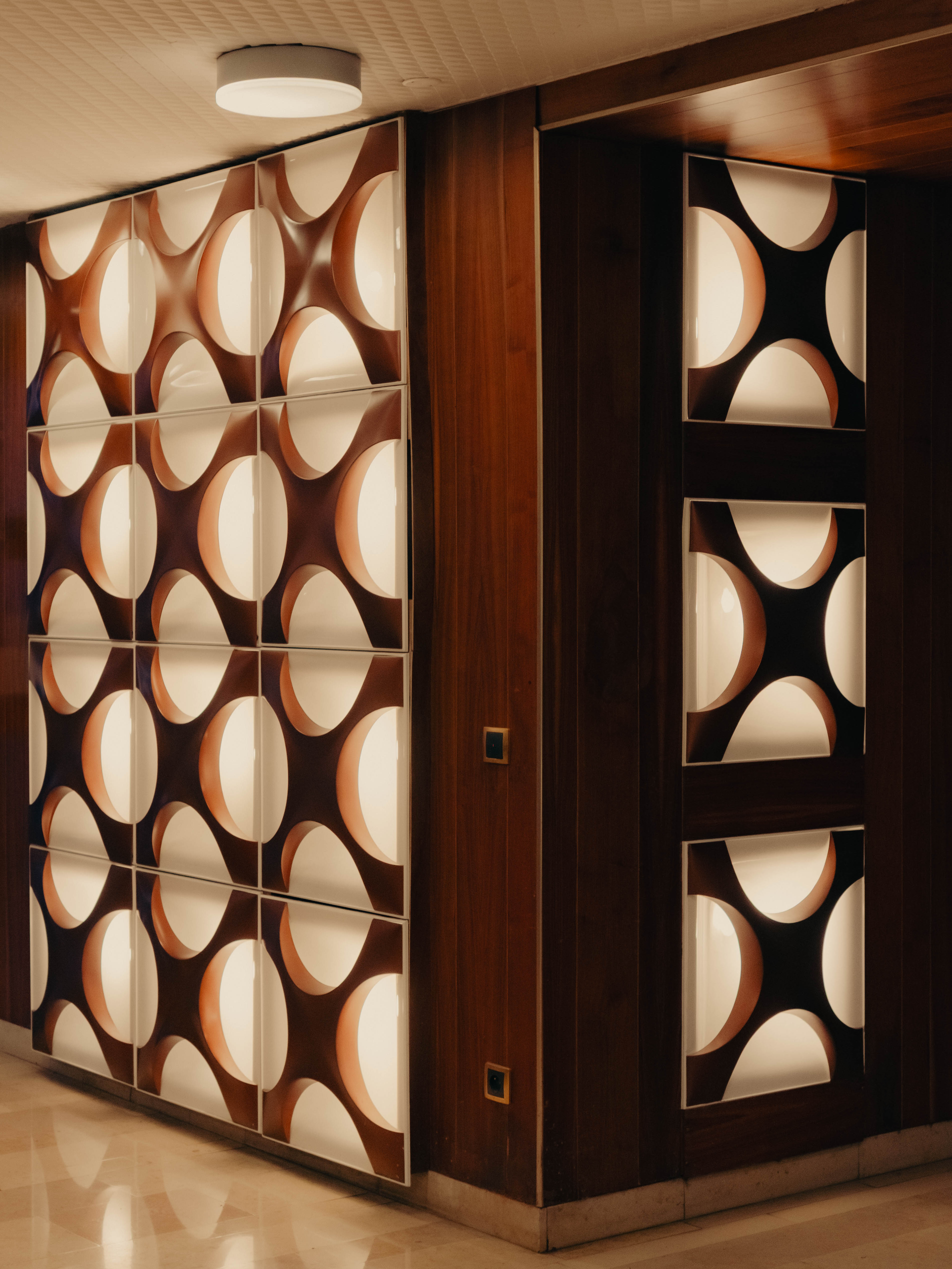 Cloison lumineuse rétroéclairée motif cercles, boiseries noyer