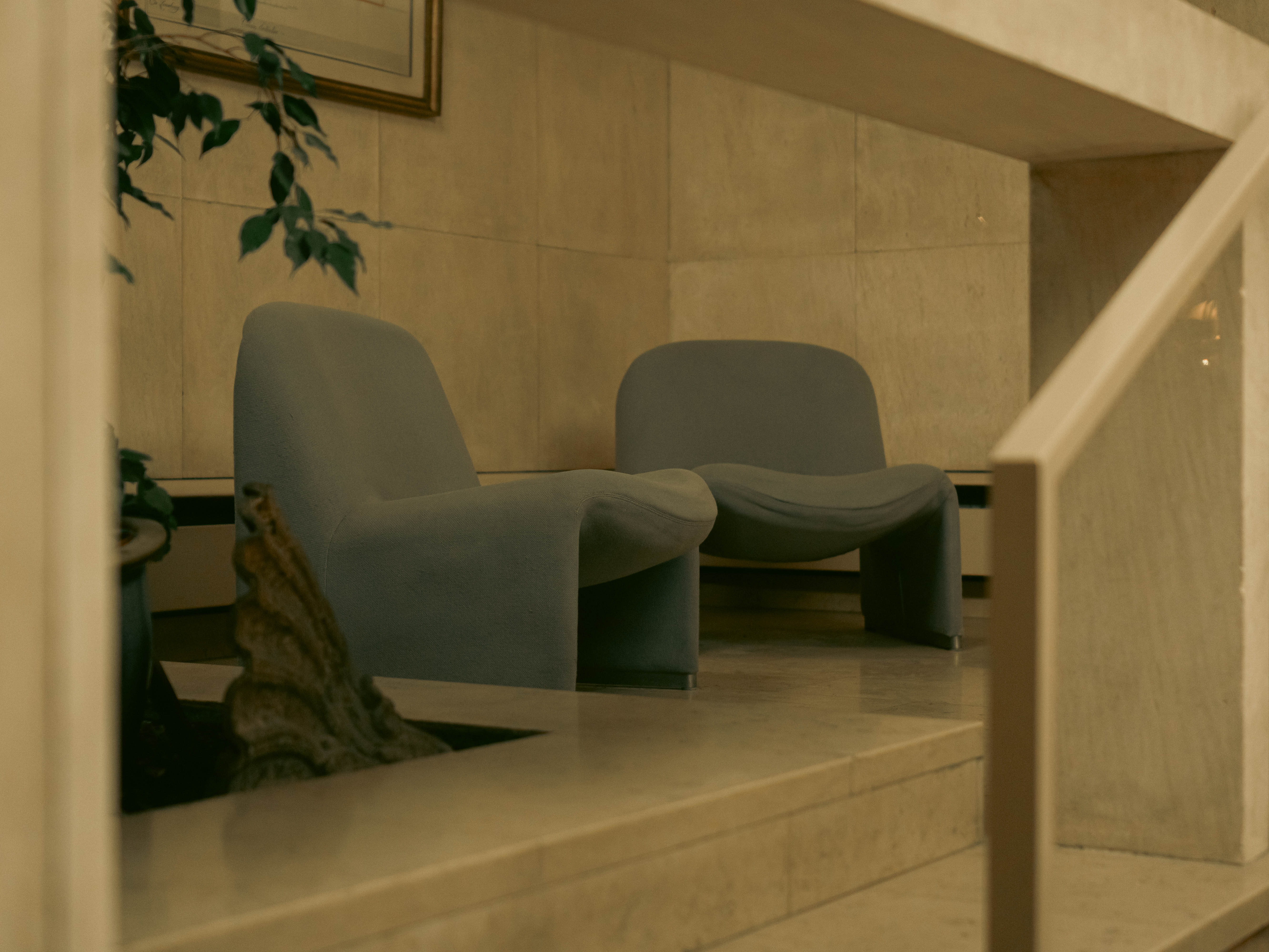 Deux fauteuils design gris-bleu sur estrade travertin — Horizon70