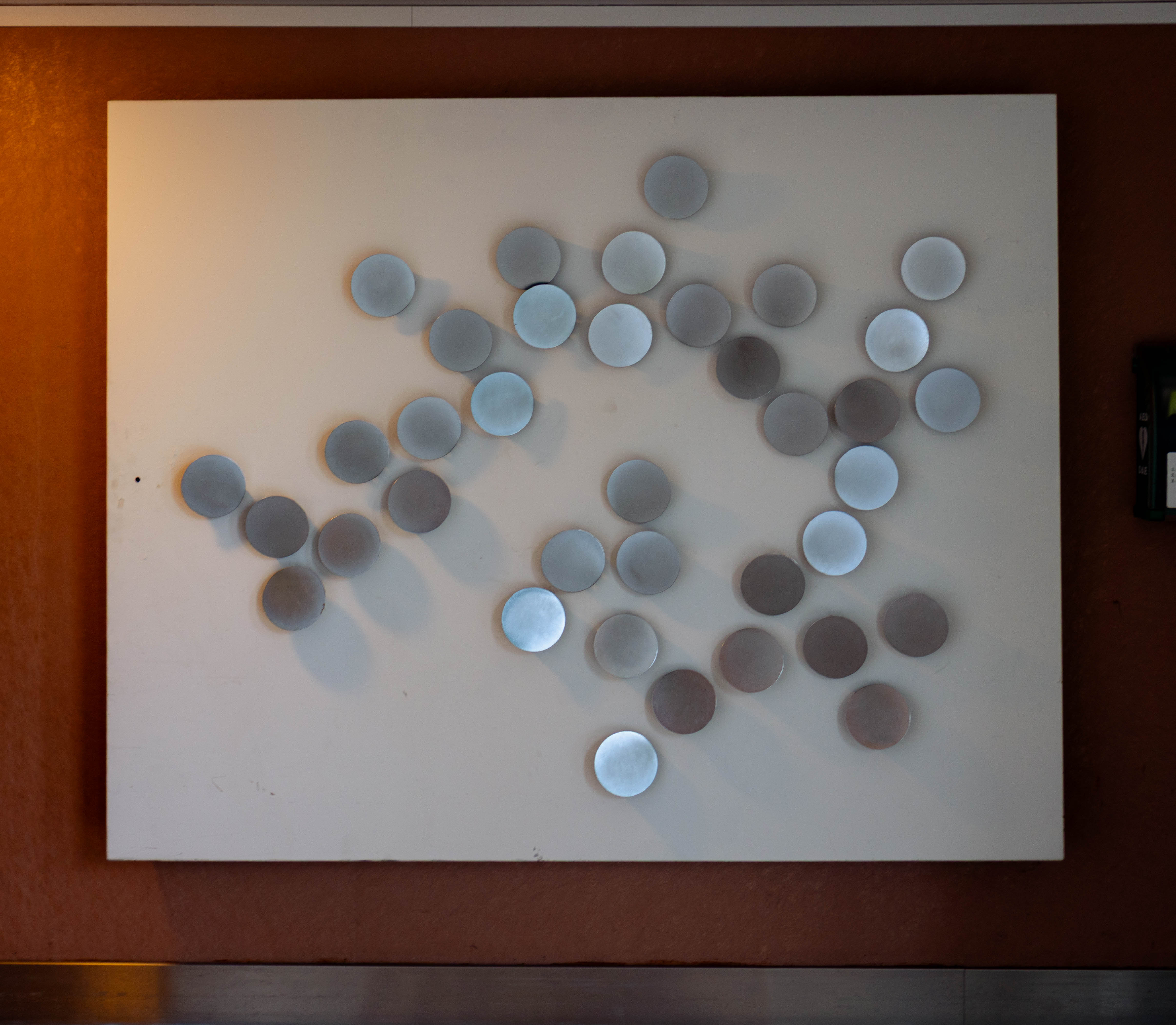 Panneau disques métalliques argentés en relief, fond blanc laqué