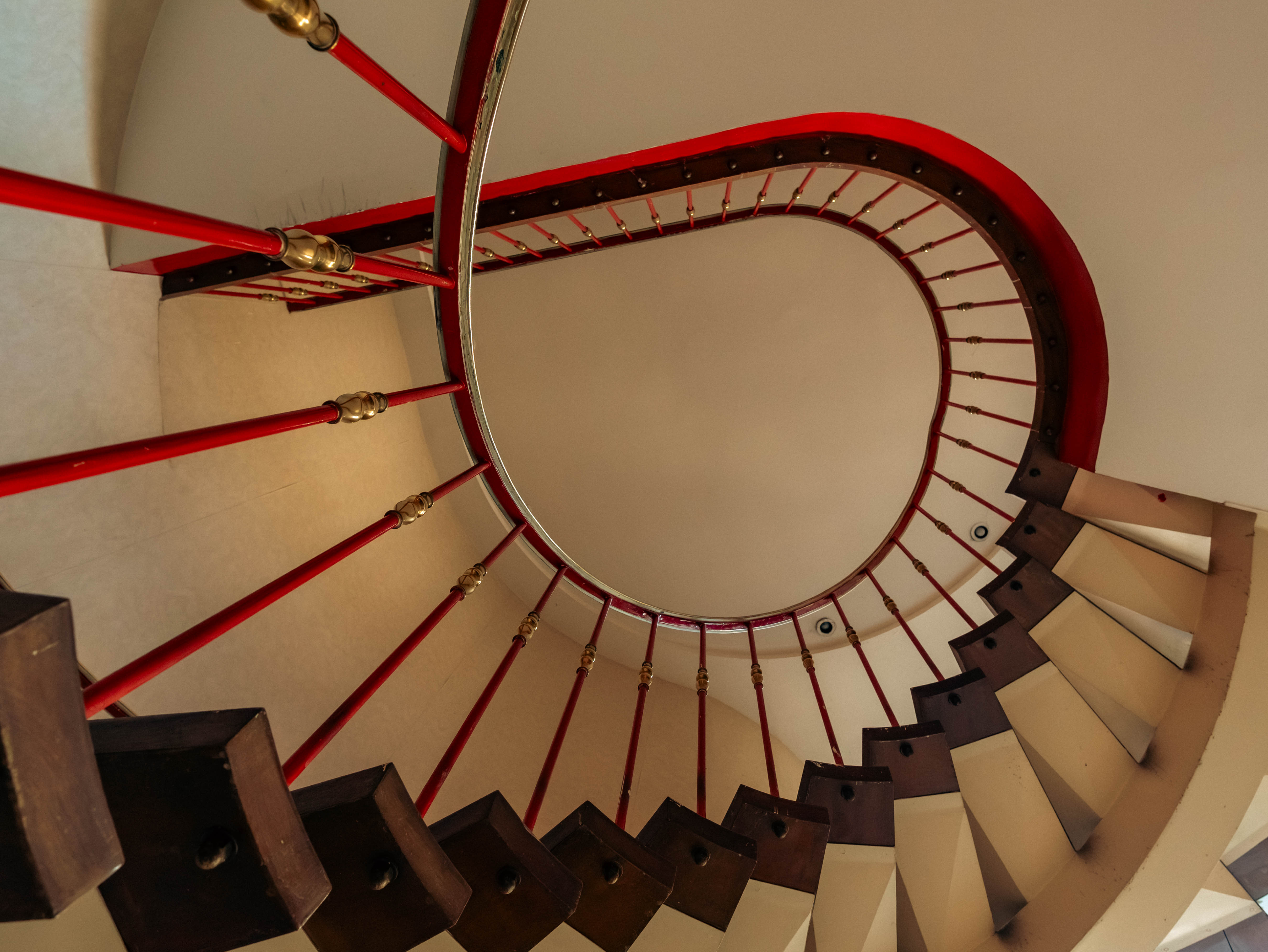 Contre-plongée spirale rampe rouge et laiton, ellipse vertigineuse