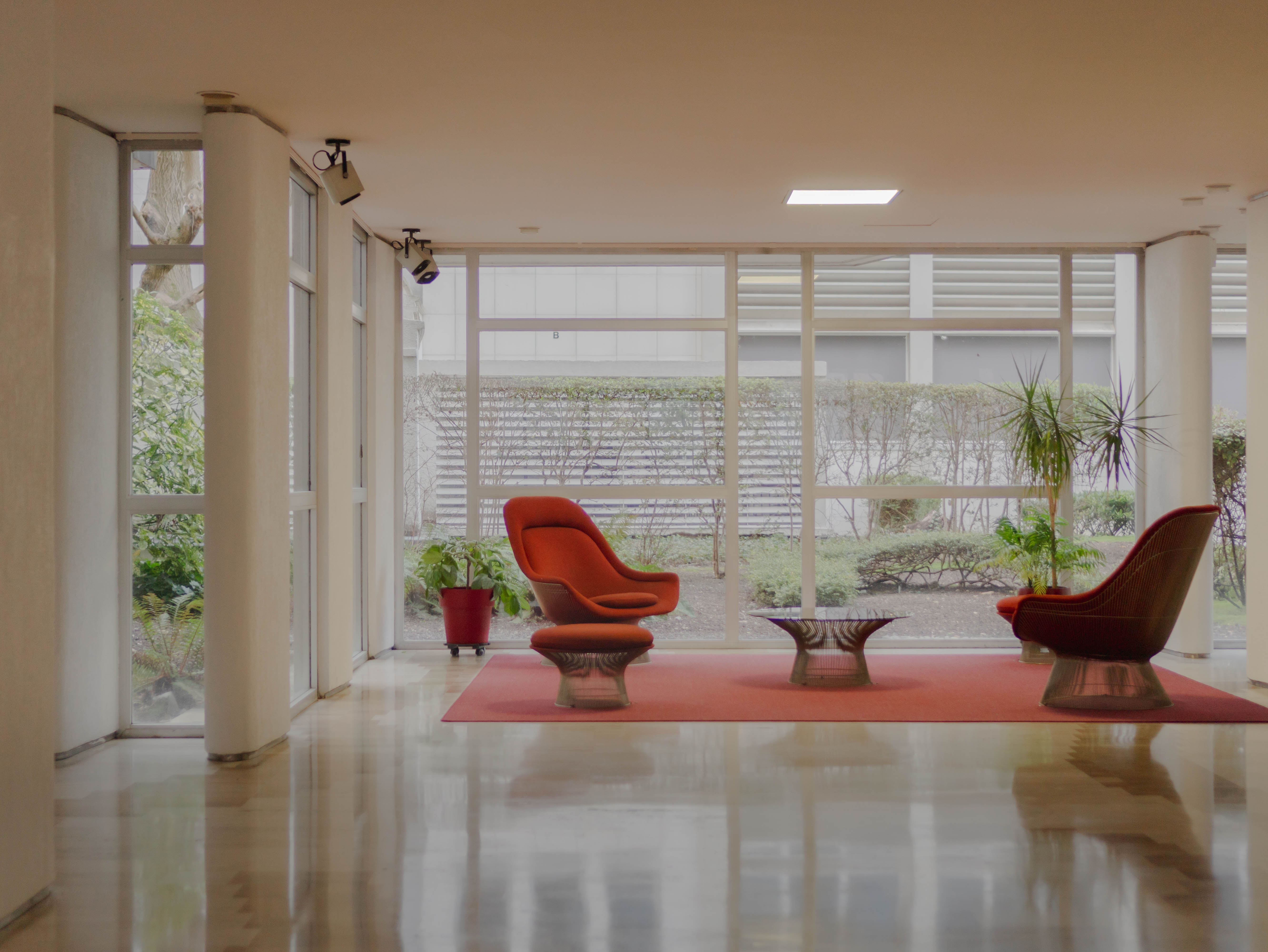 Hall moderniste années 70, fauteuils design, baies vitrées