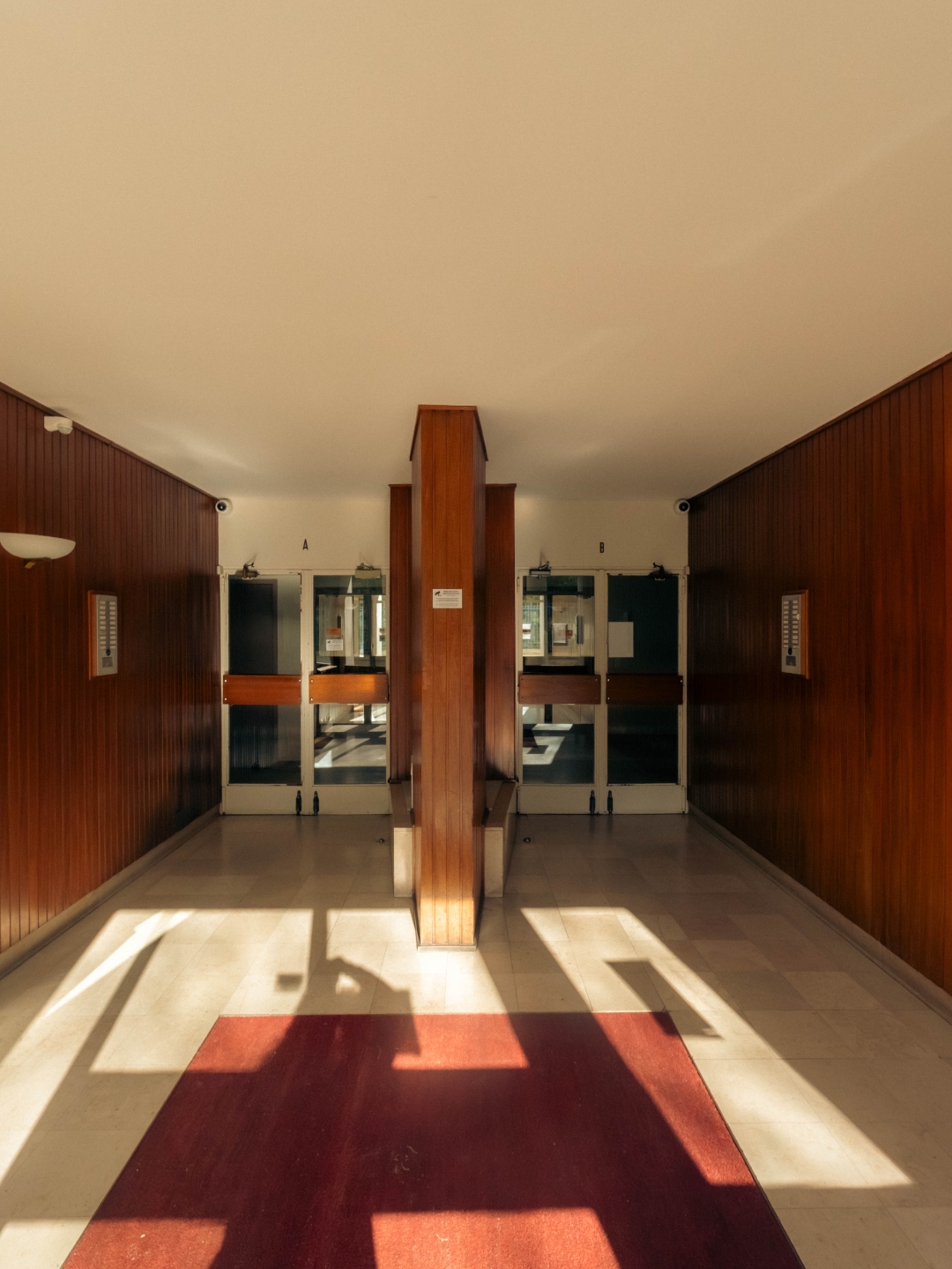 Hall — boiseries acajou, lumière rasante