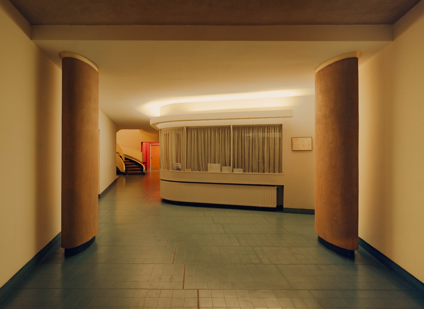 Hall — colonnes rondes, carrelage bleu, loge